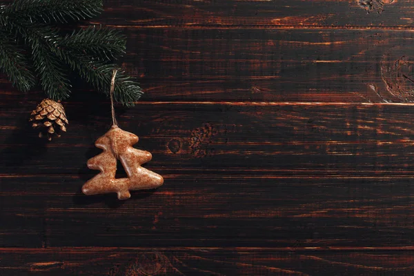 Galletas de jengibre de Navidad y ramas de pino y conos sobre un fondo de madera, espacio para copiar . — Foto de Stock