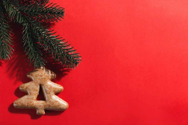 Piernik świąteczny w kształcie choinki na czerwonym tle, przestrzeń do kopiowania. — Zdjęcie stockowe