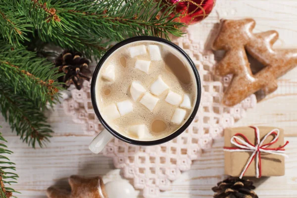 Hot Christmas drink with marshmallows in an iron mug and gingerbread cookies, on a white table. New Year, holiday background, copy space. — Stock Photo, Image
