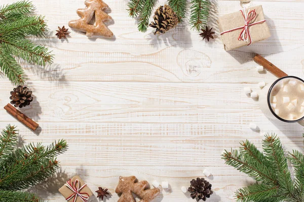 Bebida caliente de Navidad con malvaviscos en una taza de hierro y galletas de jengibre, sobre una mesa blanca. Año Nuevo, fondo de vacaciones, espacio de copia de la tarjeta de felicitación . — Foto de Stock