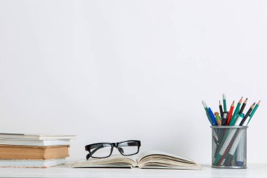 Kitaplar ve okul malzemeleri beyaz arka planda. Öğretmenler günü için kartpostal konsepti. Boşluğu kopyala.