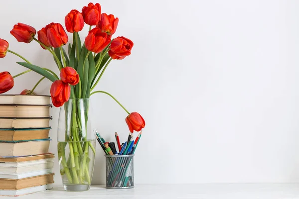 Rode Tulpen Een Vaas Boeken Schoolbenodigdheden Een Witte Achtergrond Het — Stockfoto