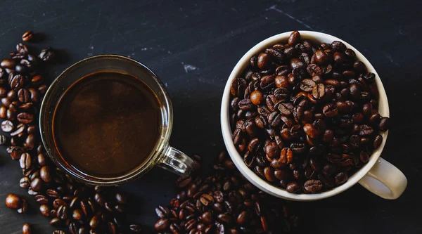 Kavrulmuş kahve çekirdeği ile sıcak espresso içki koyu arka plan üzerinde beyaz Kupası'nda. Yukarıdaki anahtar, Vintage sesi, düşük