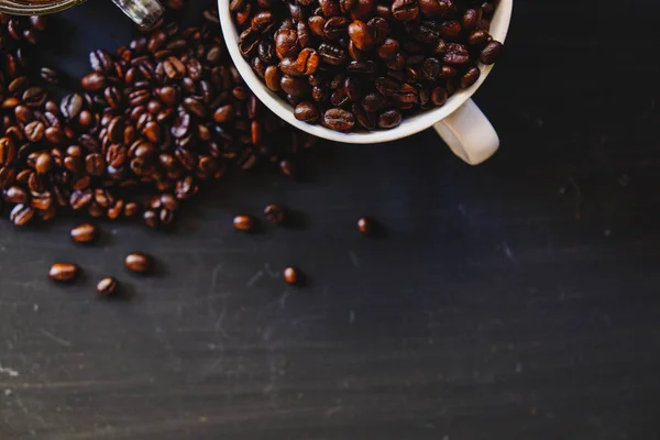 Kavrulmuş kahve çekirdeği ile sıcak espresso içki koyu arka plan üzerinde beyaz Kupası'nda. Yukarıdaki anahtar, Vintage sesi, düşük