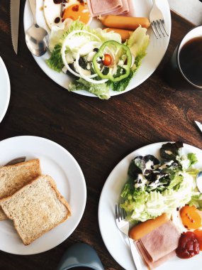 Otel kahvaltı - yumuşak haşlanmış pirinç kızarmış yumurta, pastırma, sosis, jambon, taze salata, genel gider görünümünü tost ve sıcak çay üstte ahşap bir masa