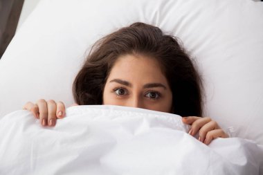 Genç güzel kadın battaniye yatakta yatarken altında gizleme