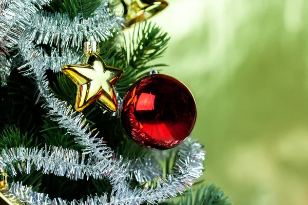 Close-up van kerstboom versierd met ornamenten in rijke glanzende gouden achtergrond - met copyspace. — Stockfoto