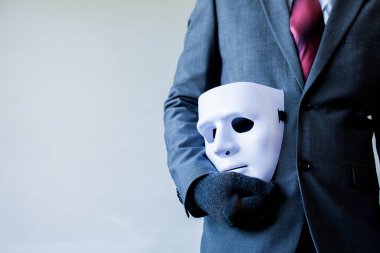 Business man carrying white mask to his body indicating Business fraud and faking business partnership. clipart