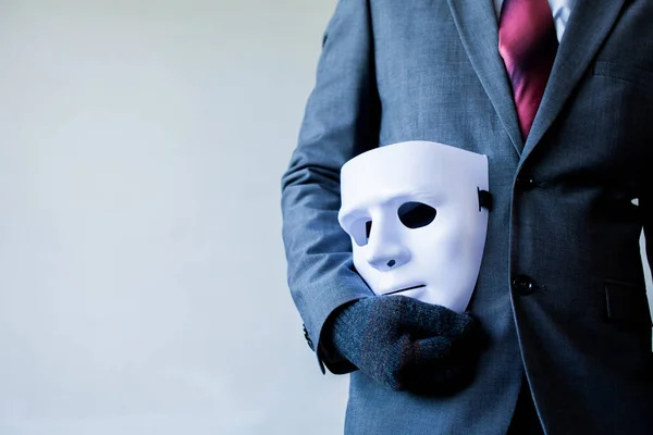 Pria bisnis membawa topeng putih ke tubuhnya menunjukkan penipuan bisnis dan memalsukan kemitraan bisnis . — Stok Foto