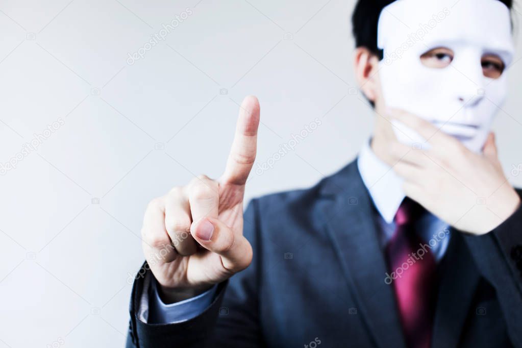 Anonymous businessman in mask hiding himself touching on virtual screen - with copyspace.