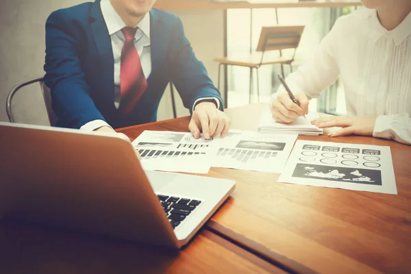 Hombre de negocios y mujer de negocios discutiendo y señalando documentos financieros y de estrategia con el ordenador portátil durante la reunión de negocios — Foto de Stock