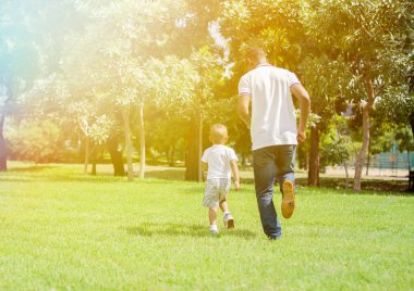 Baba ve oğul çalışan ve her diğer yeşil parkta takip