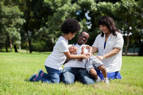 İyi vakit geçiriyor ve bir çocuk parkta gıdıklıyor mutlu aile — Stok fotoğraf