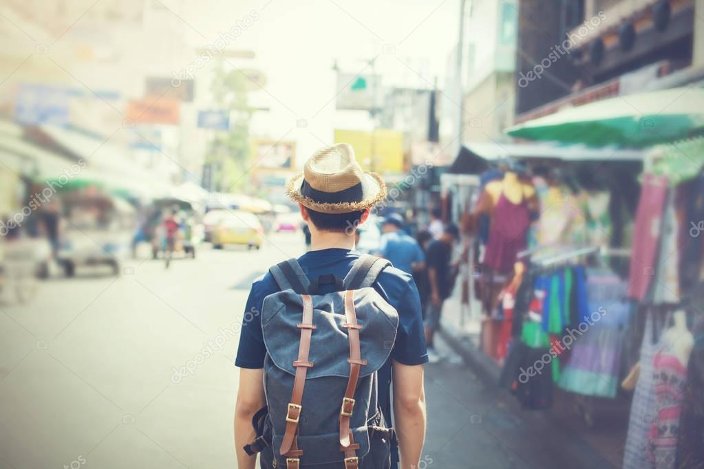 Young Asian traveling backpacker in Khaosan Road outdoor market in Bangkok, Thailand