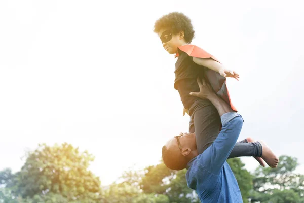 Padre che tiene insieme e aiuta il bambino super eroe volante nella felicità — Foto Stock