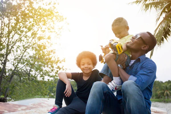 Mutlu Afrikalı-Amerikalı babası, oğlu ve kızı neşeli an birlikte park açık zevk — Stok fotoğraf