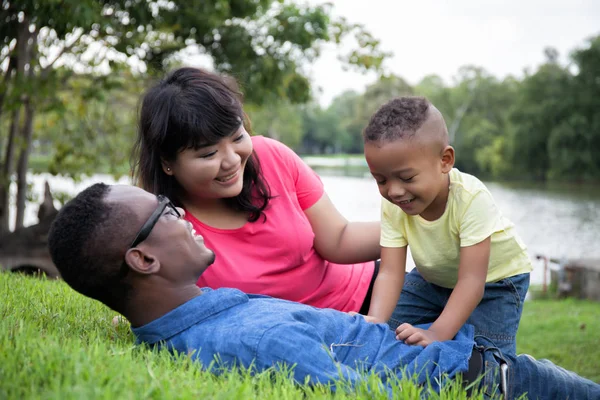 Afro-Amerikan aile ve rahatlatıcı ve yeşil park kopya alanı ile oynarken küçük çocuk — Stok fotoğraf