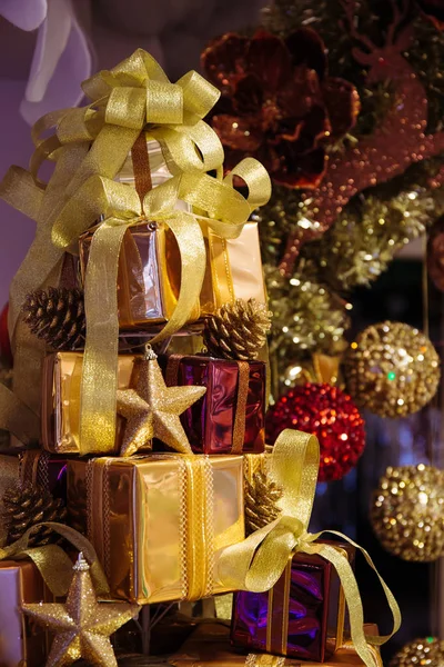 Noel ağacı İsa ile dekore parlak hediye kutuları yığını — Stok fotoğraf