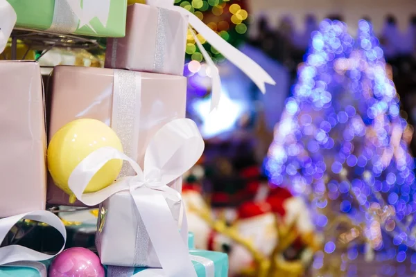 Noel ağacı aydınlatma ile dekore edilmiş hediye kutuları yığını süslenen Noel ağacı içinde belgili tanımlık geçmiş Kopyala alanına sahip — Stok fotoğraf