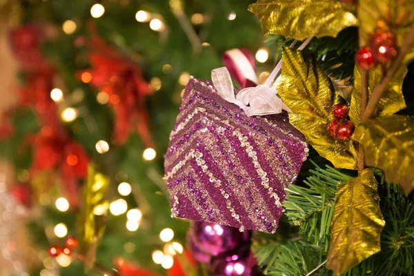 Prachtig versierde kerstboom achtergrond met roze geschenk doos en xmas versieringen — Stockfoto