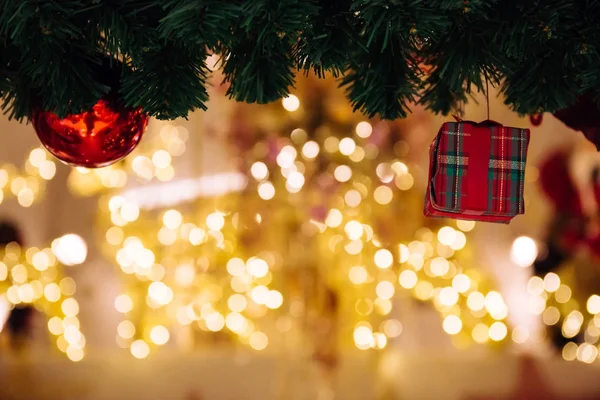 Prachtig versierde kerstboom achtergrond met rode gift box en xmas versieringen — Stockfoto