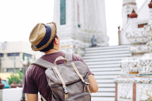 Young Asian traveling backpacker in Wat Pho with India inspired 