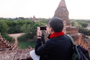 Genç adam tapınak stupa mimari sahne cep telefonu ile fotoğraf çekme