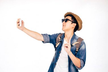 Gülümseyen ve beyaz arka plan üzerinde izole selfie fotoğraf çekme smartphone elinde şapka ile genç Asya turizm