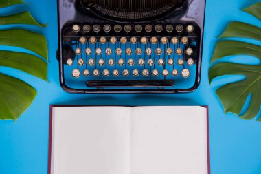 Açık kitap boş kağıt sayfaları ile dekore edilmiş daktilo ve l
