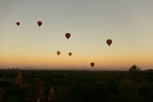 Balon udara panas mengambang di sekitar situs warisan pagoda Burma selama lanskap matahari terbit — Stok Foto