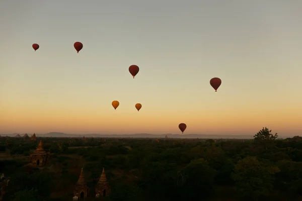 Montgolfières flottant autour du site patrimonial de la pagode birmane pendant le lever du soleil — Photo