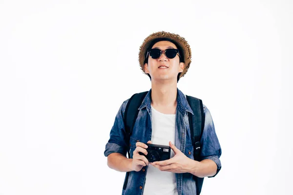 Young Asian tourist with hat and sunglasses smiling and holding camera isolated over white background — Stock Photo, Image