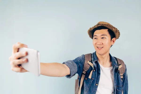 Jonge Aziatische toeristische glimlachend en het nemen van een selfie geïsoleerd over pastel blauwe achtergrond — Stockfoto