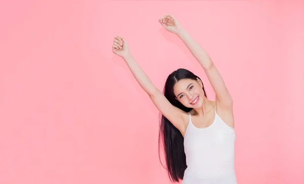 Feliz e alegre sorrindo asiático 20s mulher levantando as mãos para sentimento positivo e celebração isolado sobre fundo rosa — Fotografia de Stock