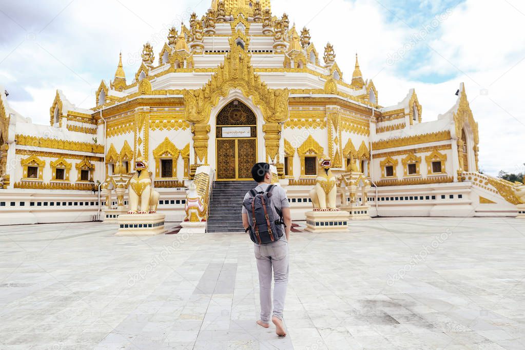 Back of young man backpacker walking towards Burmese temple named Buddha  Relic Tooth Pagoda in Yangon, Myanmar