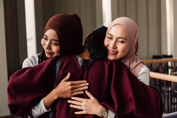 Muslim women hugging friend of different culture — Stock Photo, Image