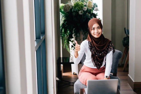 Cheerful Islamic female with laptop gesturing thumb up — Stock Photo, Image