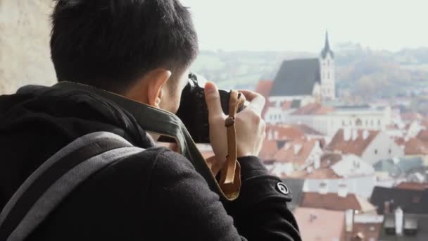 ヨーロッパの市内中心部で若いアジアの旅行バックパッカー。チェコスキー・クルムロフの旧市街の写真を撮る男 — ストック動画