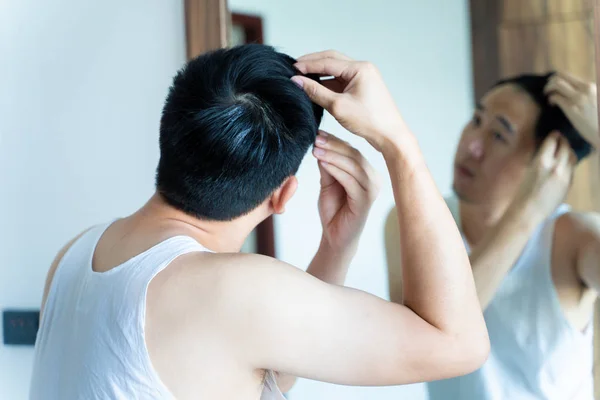 Ung asiatisk kille styling hår i badrummet — Stockfoto
