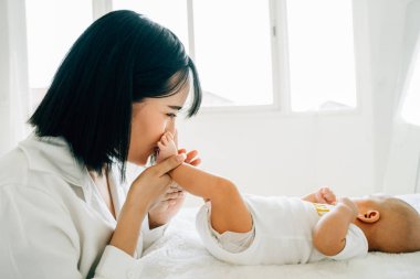 Anne yeni doğmuş bebeğin ayaklarını öpüyor.