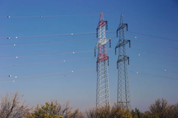 青い空の上の電気高電圧ポールとパワーポール電圧ライン — ストック写真