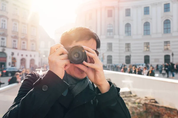 Ung asiatisk man turist ta bilder med kamera i händerna nära Hofburg palats i Wien, Österrike, Europa. Berömd populär turistort i Europa — Stockfoto