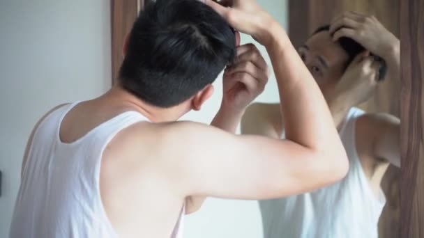 Молодой азиат, укладка волос в ванной — стоковое видео