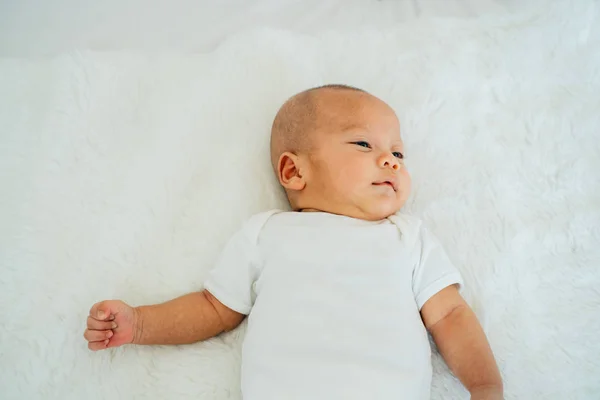 Calma bebé asiático recién nacido acostado en la cama — Foto de Stock