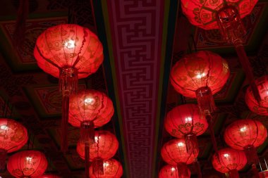 Many illuminated red Chinese lanterns with some Chinese characters on it