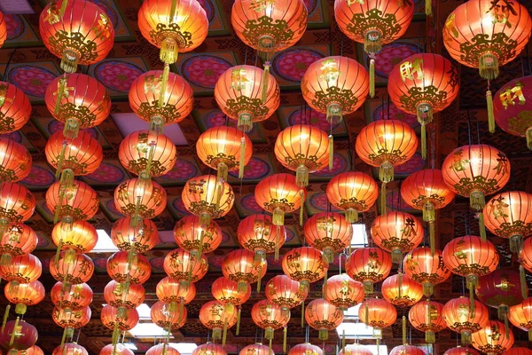 Many illuminated red Chinese lanterns with some Chinese characters on it