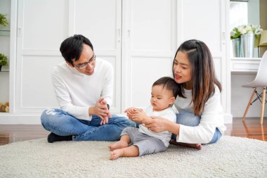 Young parents with little boy playing at home