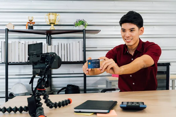 Gelukkig aziatische man opname video verkopen spul tonen credit card — Stockfoto