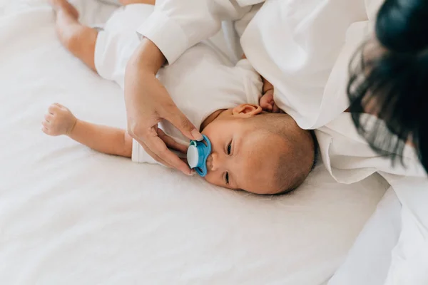 Mother putting pacifier into newborn baby mouth — 스톡 사진