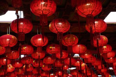 Many illuminated red Chinese lanterns with some Chinese characters on it